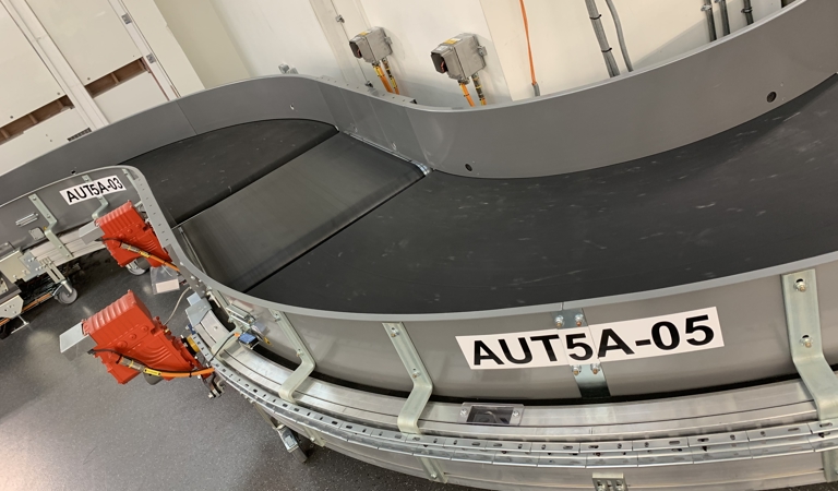 Powered curves for airport baggage handling